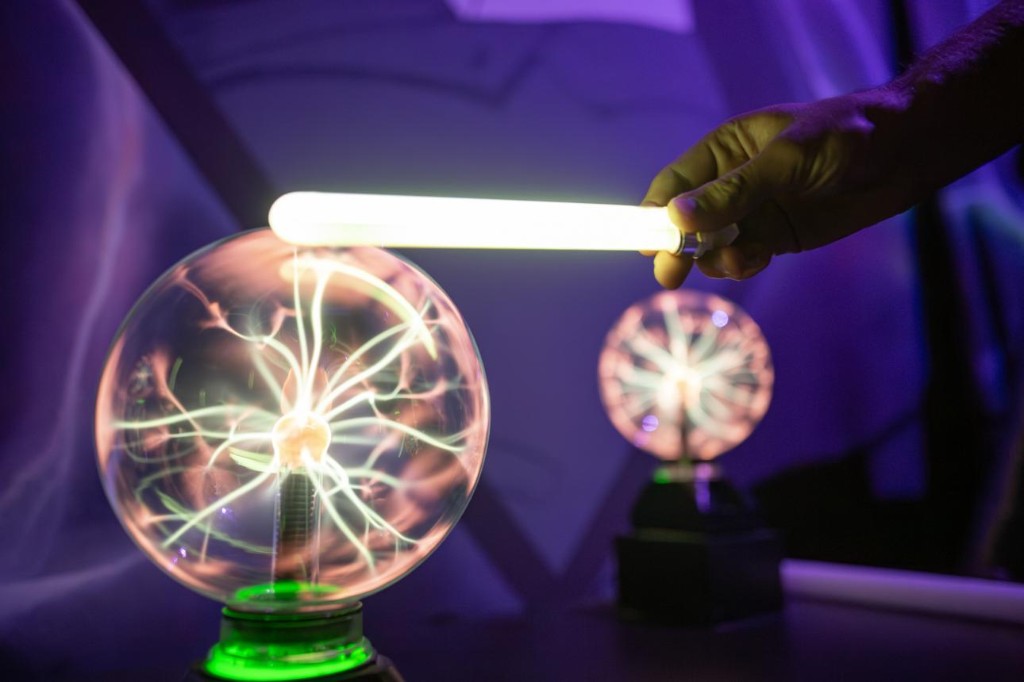 A fluorescent tube glowing from wireless electricity with no obvious wired connection